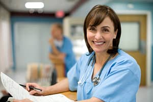 Happy Female Nurse at Nurse's Station