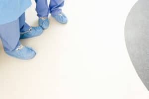 View of Clean Medical Floor including Lower Legs of Medical Workers in Blue Surgical Garb